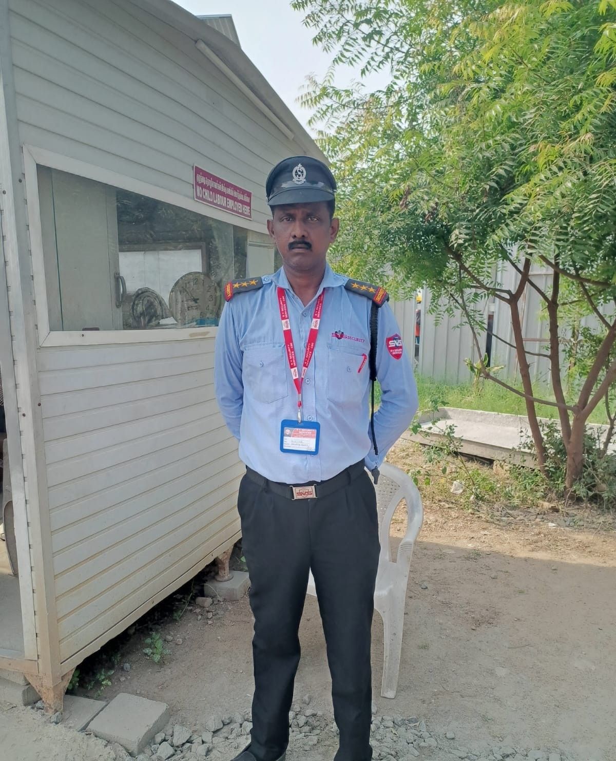 An SV Security Services guard on duty at a client gate post.