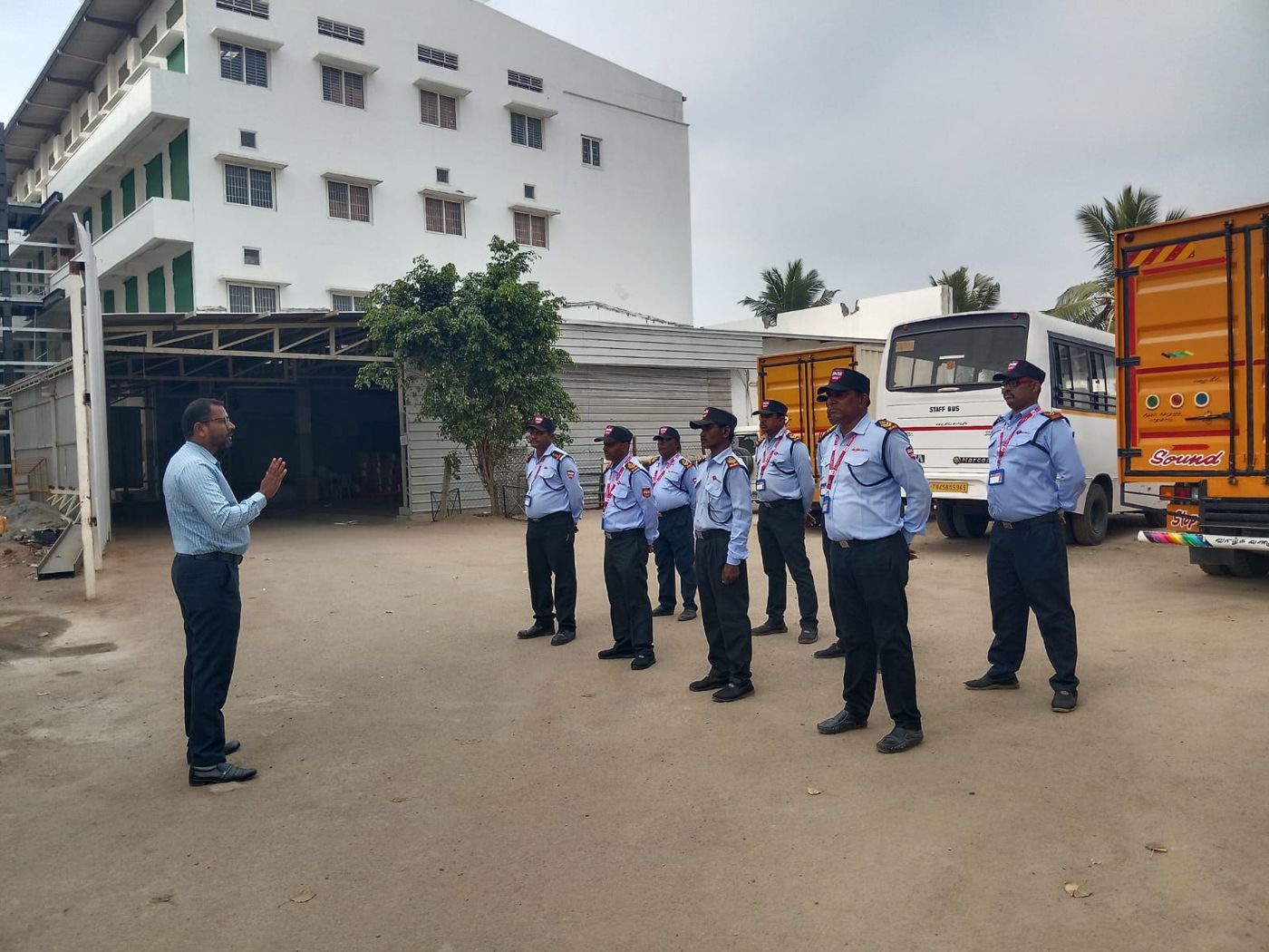 Shift handover beside the staff bus at an industrial unit in Coimbatore.
