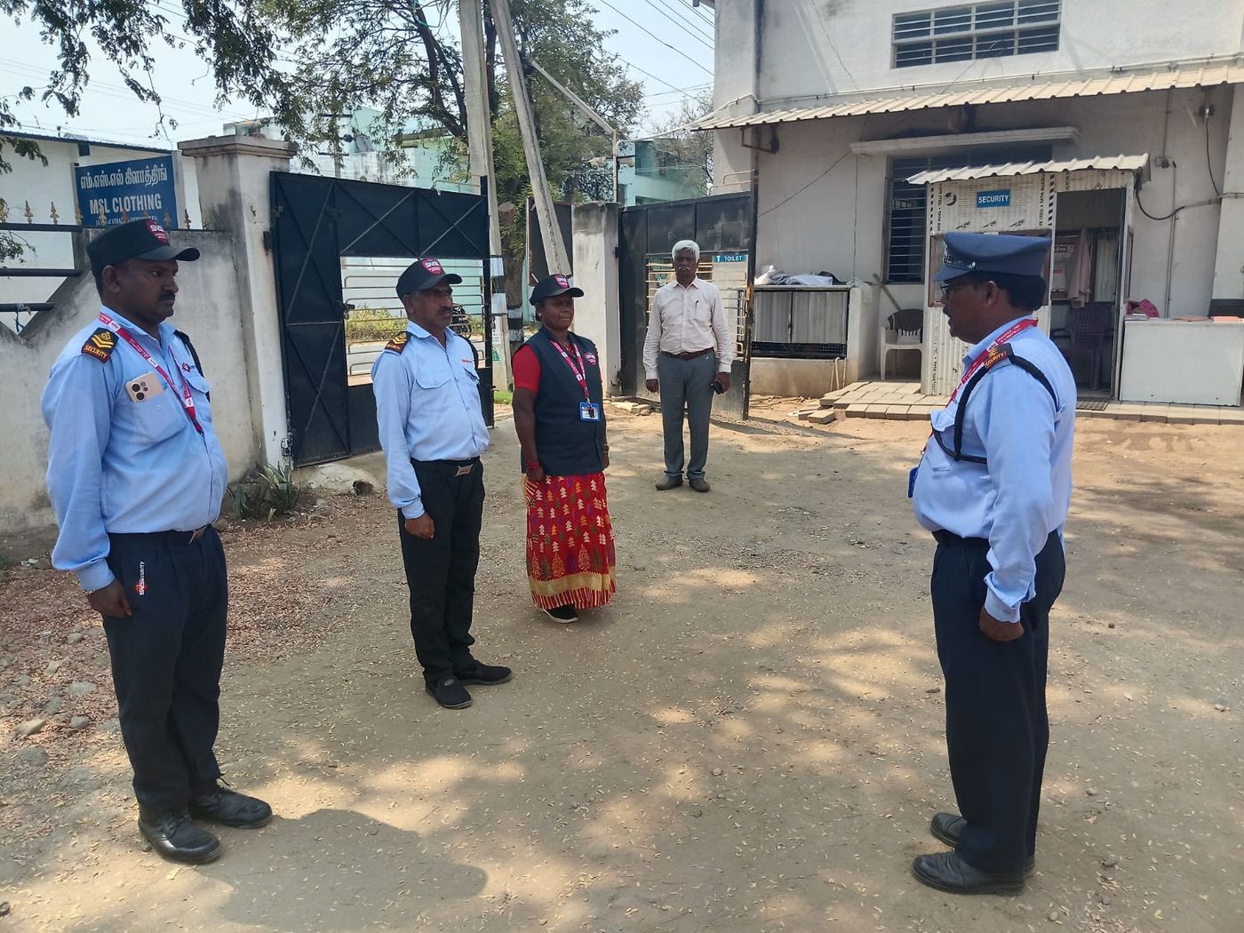 An SV supervisor making an unannounced field check at a garment unit gate.